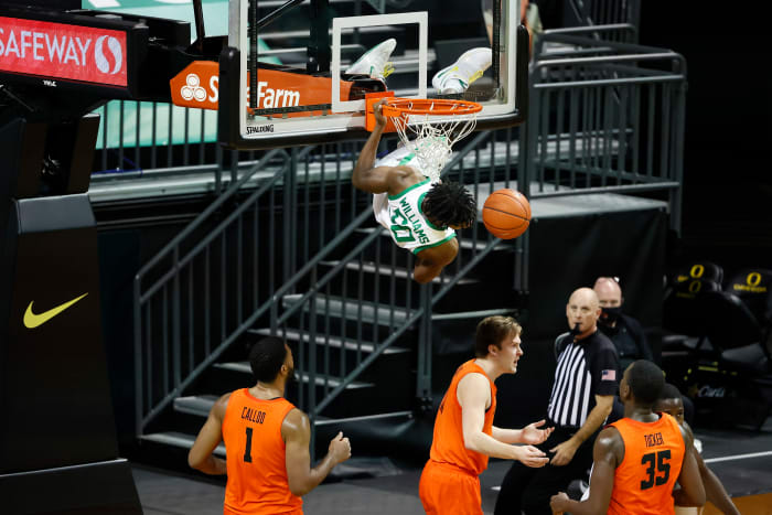 Eric Williams Jr. (50) hangs from the rim after throwing down a dunk against Oregon State on January 23, 2021 at Matthew Knight Arena in Eugene, Oregon.